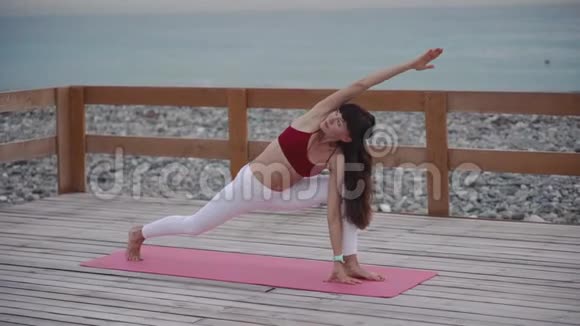 中年妇女在海滩上做瑜伽视频的预览图