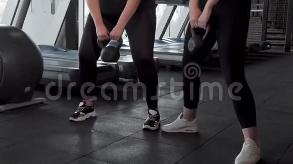 两个以上大小的运动女性在健身房用水壶铃锻炼的滑射视频的预览图