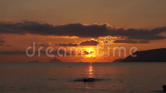 人们在日出时以太阳为背景在朝霞中游泳视频的预览图