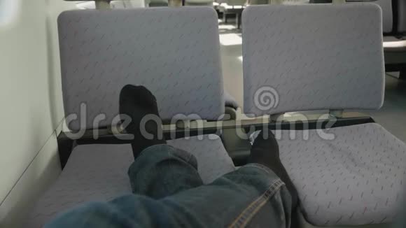 男人穿黑色袜子腿的景色乘客在火车上靠椅子休息在旅途中休息视频的预览图