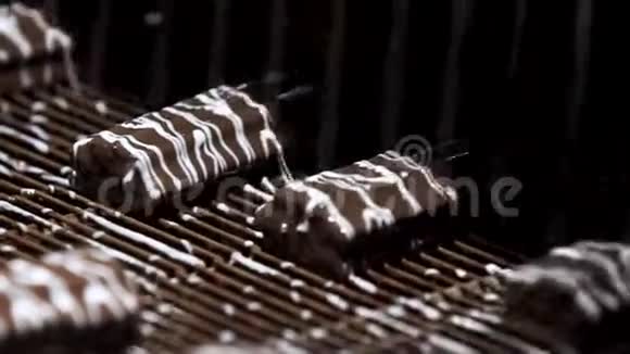 机器在糖果上倒入液体带棕色糖果的传送带制作优质甜品在水流下视频的预览图
