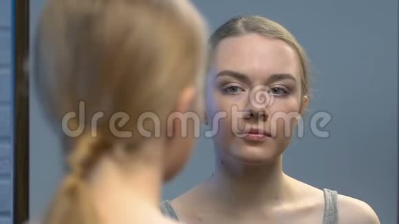 少女照镜子欣赏自己的美丽准备第一次约会视频的预览图