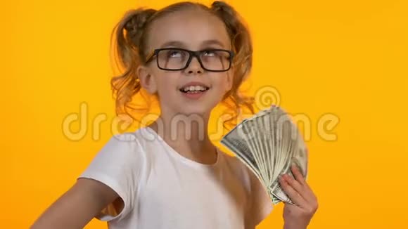 戴眼镜的金发小孩拿着一堆钱第一笔钱收入不错视频的预览图