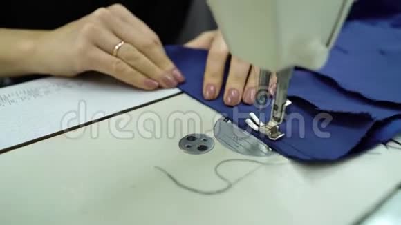 女裁缝手中的蓝色布料时尚装饰视频的预览图