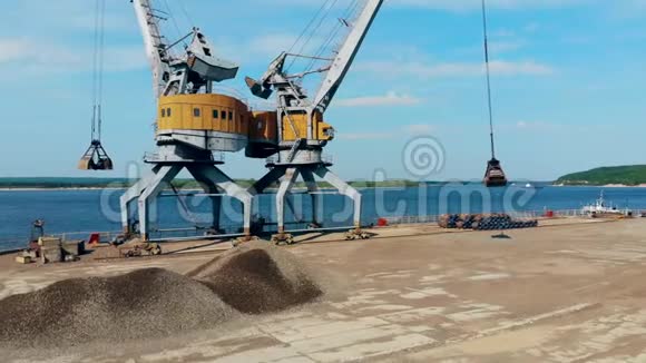 一个起重机在一个桶里搬运石头在码头工作视频的预览图