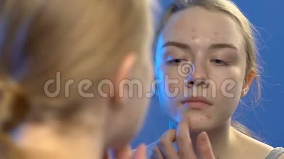 年轻女士用粉底霜掩盖脸上的粉刺皮肤病视频的预览图