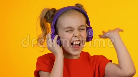 非常快乐的孩子用耳机听音乐欣赏最喜欢的歌曲视频的预览图