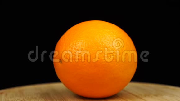 橘子放在木板上旋转360度黑色背景视频的预览图