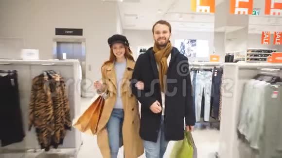年轻幸福的一对夫妇带着购物袋慢动作视频的预览图