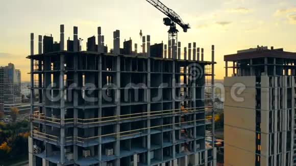 城市日落和一栋多层房屋在建施工现场鸟瞰图视频的预览图