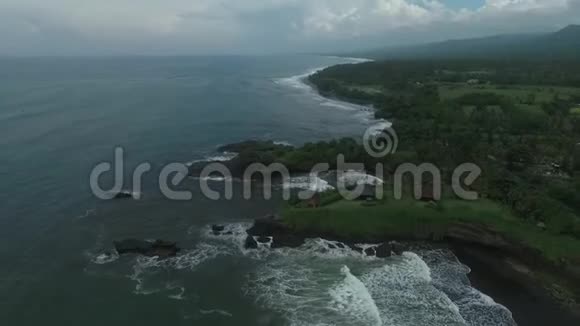 巴厘岛附近海洋的高角度视野多岩石的海岸线上长满了草视频的预览图