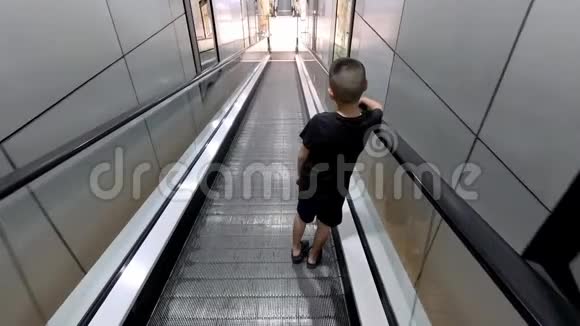 扶梯上的亚洲男孩正在往下移动视频的预览图