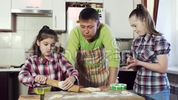 一位家庭父亲在厨房里和他的女儿聊天一边煮面团视频的预览图