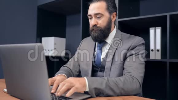 肖像中年商人使用笔记本电脑办公视频的预览图