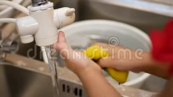 亚洲小宝宝的专注她的手拿着海绵独自在厨房的水槽里洗手视频的预览图