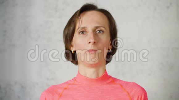 一位成年女性在面部健身前镜头下鼓起脸颊做面部体操的美女博主面部皮肤视频的预览图