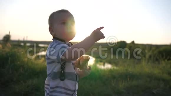 一个小男孩在大自然中吃馅饼在天空中展示一些东西视频的预览图