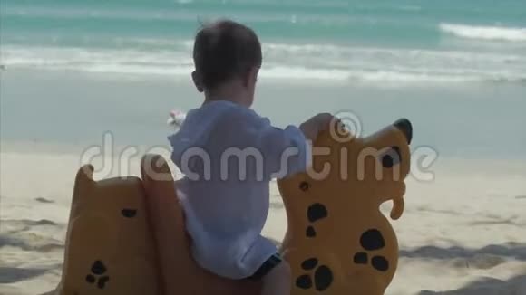 可爱的小白种人婴儿23岁幼儿小男孩在海洋背景下玩阳光夏日户外活动视频的预览图
