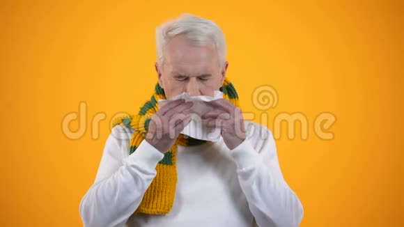 戴围巾的老年男性在组织风湿病或鼻炎流感症状中吹鼻视频的预览图