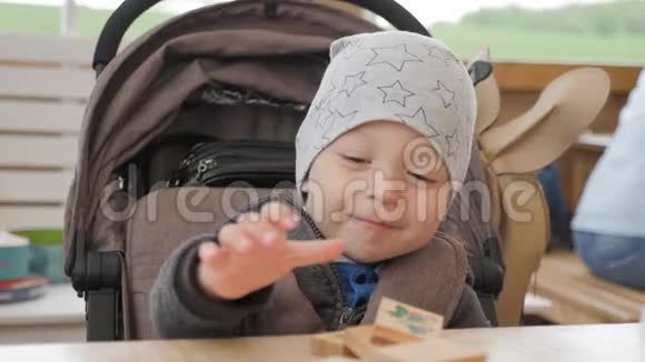 小男孩在咖啡馆的一张桌子上玩木方块视频的预览图
