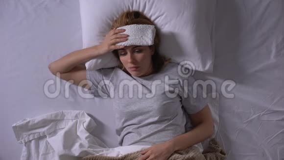 患有偏头痛的妇女躺在床上受压迫服用避孕药视频的预览图
