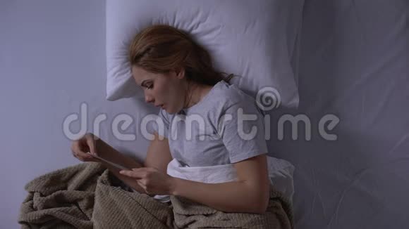 悲伤的女人在睡觉前看着心爱的男人的照片想念他俯视视频的预览图
