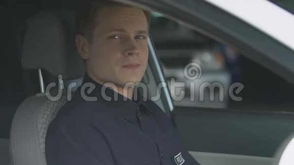 友好的警察微笑着坐在巡逻车的驾驶座上视频的预览图