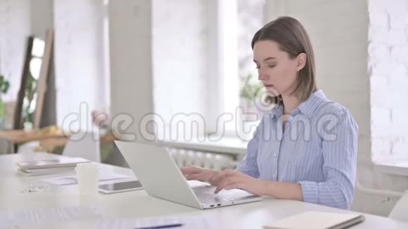 疲惫的年轻女子在现代的办公室里视频的预览图