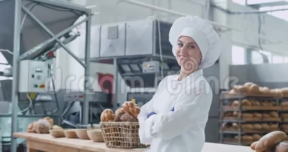 在一个大面包店里美丽而有魅力的女面包师穿着时尚的制服在镜头前大笑着视频的预览图