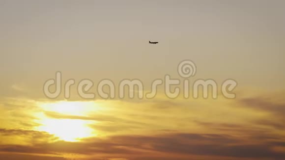 在日落的天空上飞行的运输飞机橙色日落时向上飞行的飞机剪影视频的预览图