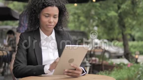 震惊的非洲妇女因坐在户外咖啡厅的平板电脑上的损失而心烦意乱视频的预览图