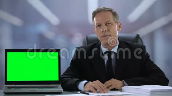 绿色屏幕笔记本电脑靠近微笑男士西装商务申请推荐视频的预览图
