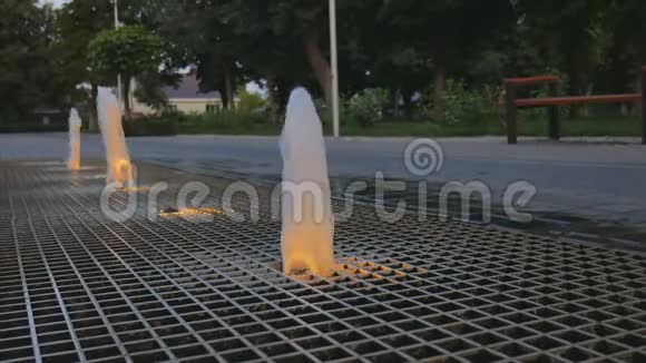 晚上公园的小喷泉水通过铁栅子喷射视频的预览图