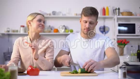 年轻的幸福家庭调情烹饪生菜沙拉健康的生态食品视频的预览图
