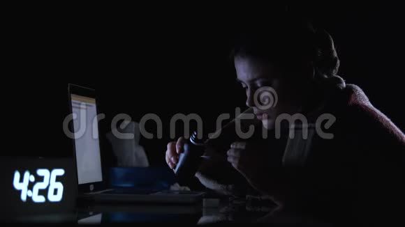 生病的女士晚上坐在电脑前喝糖浆有流感症状视频的预览图