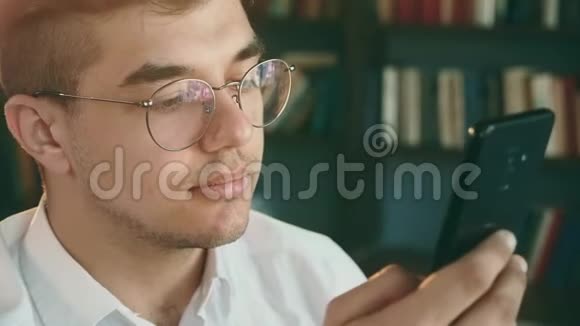 手机里戴眼镜的男人的特写人上网就近了视频的预览图