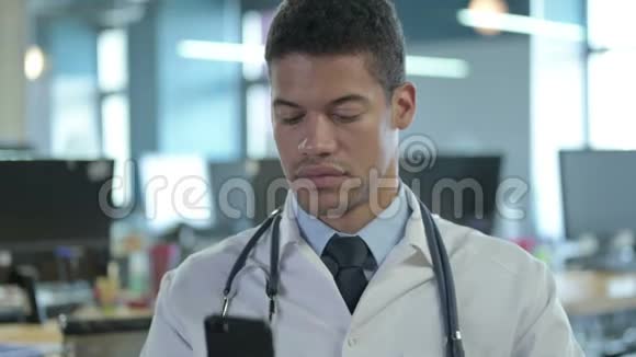 非洲医生在办公室用智能手机说话的肖像视频的预览图