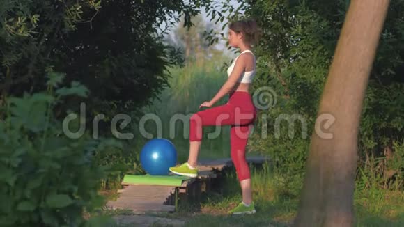 大自然的体操活跃的美丽女性在户外木制健身运动中进行伸展运动视频的预览图