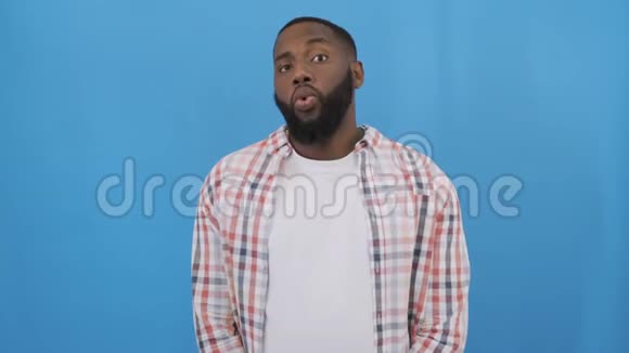 年轻的非裔美国人穿着休闲衬衫站在白色的背景上做着快乐的竖起大拇指的手势视频的预览图