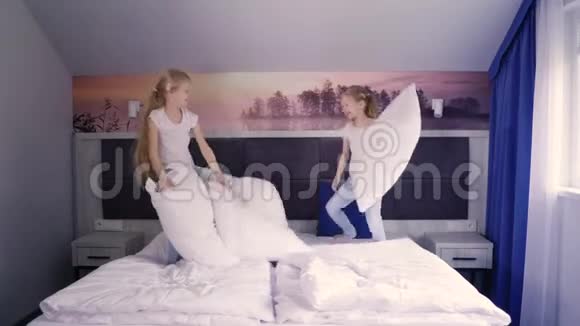 双胞胎在床上抱着枕头打架视频的预览图