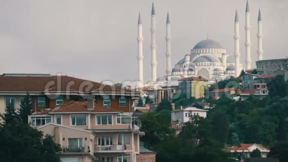 居住区背景下的一座大型美丽的白色清真寺从大海和旅游船经过的景色视频的预览图