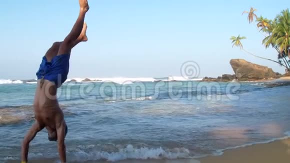 穿着蓝色短裤的运动员进入海洋掀起浪花视频的预览图
