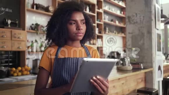 体贴的女咖啡馆老板使用数字平板电脑视频的预览图
