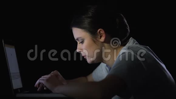 学生深夜在笔记本电脑上打字厌倦了复杂的面罩视频的预览图