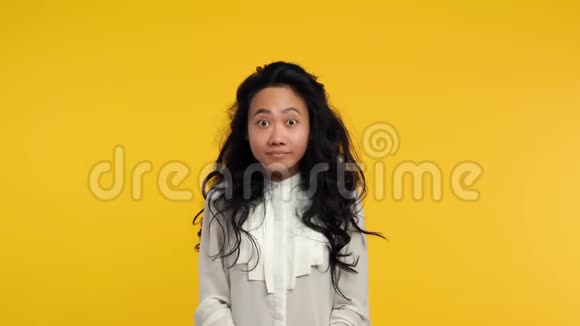 快乐的亚洲女孩在黄色背景下竖起大拇指视频的预览图