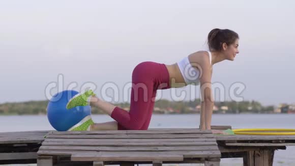 自然健身年轻有魅力的女性在自然桥上锻炼腿部肌肉时做运动锻炼视频的预览图
