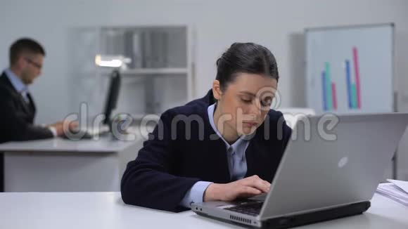 女经理在笔记本电脑前工作场所与睡眠欲望作斗争视频的预览图