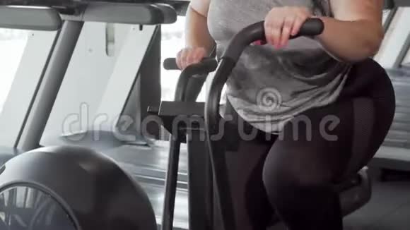 可爱开朗加上身材的女人微笑着对着相机骑着自行车锻炼视频的预览图