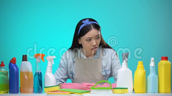 困惑的家庭主妇在洗涤剂环保清洁化学品之间的选择视频的预览图