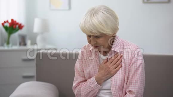 老年女性手按胸患有心脏病健康问题视频的预览图